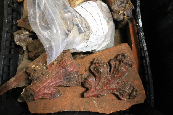 The large red painted iron leaves found in the demolition rubble beside the central garden bed.