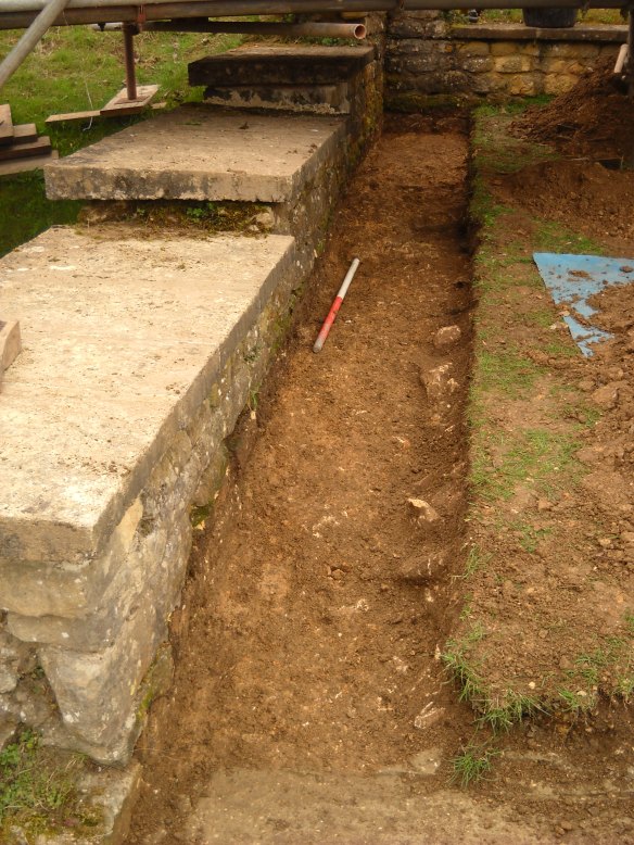  trench along the south-west side of the kitchen was to understand the Roman floor level. In the south-west corner the cement floor is well preserved but it has been cut away when the villa was demolished and the ground slopes down to visitor access path from where the photo was taken.